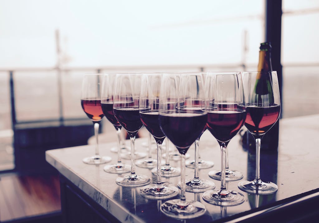 A collection of red wine glasses elegantly arranged on a bar table, perfect for events.